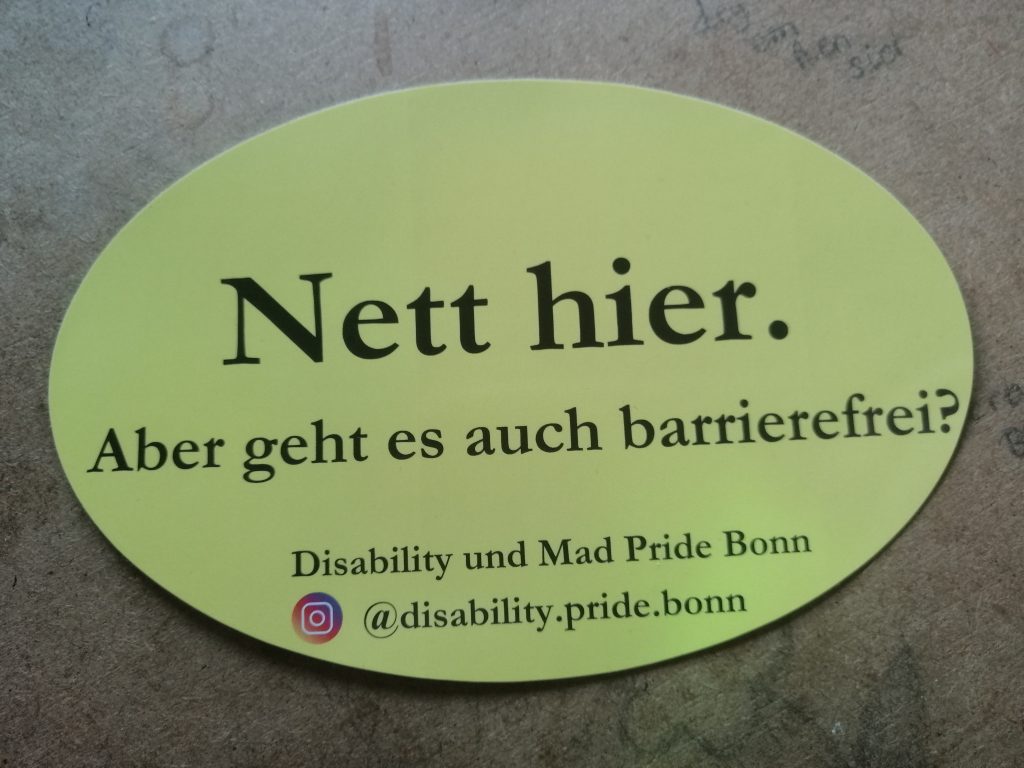Wir orientieren uns am Sticker "Nett hier. Aber kennen Sie Baden-Württemberg". Wir machen daraus vor gelbem Hintergrund: Nett hier. Aber geht es auch barrierefrei? Darunter steht: Disability und Mad Pride Bonn. Und unser Instagram-Account ist verlinkt.