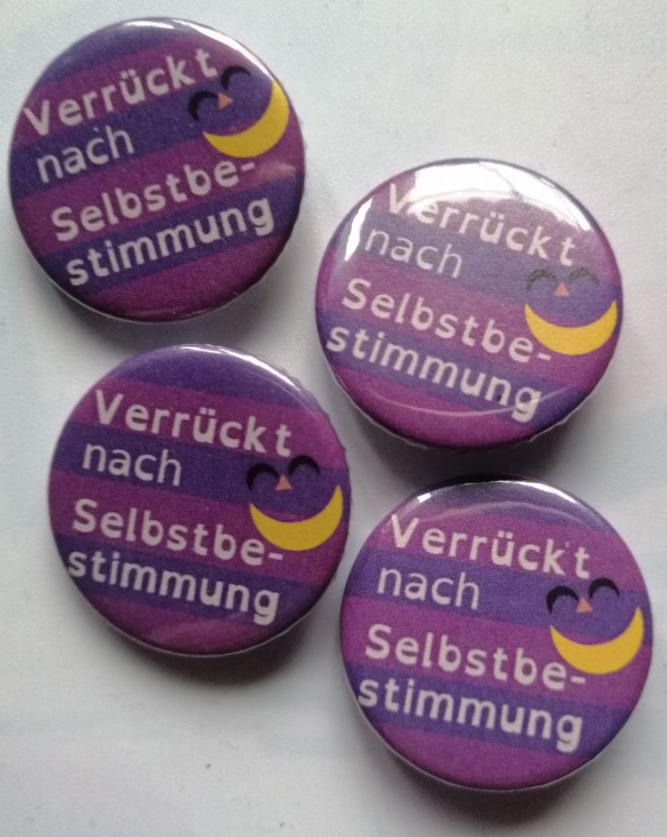 Verrückt nach Selbstbestimmung mit Mad Pride Fahne und Grinsen