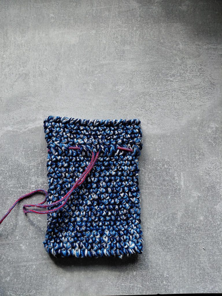 Ein blaues selbst gehäkelte Säckchen.